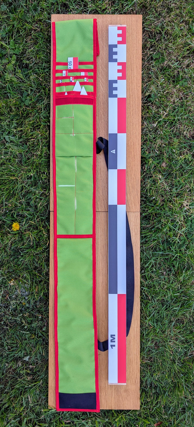 Load image into Gallery viewer, CANO 100 cm archaeological photo-scale kit with red-white-black scales and north arrows in open green case on grass