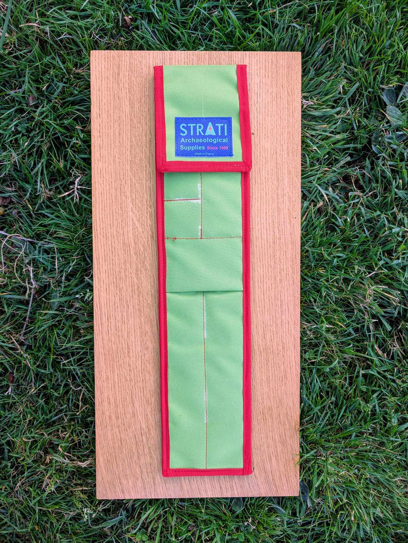Load image into Gallery viewer, Closed CANO 50 cm green and red STRATI carrying case for archaeological photo-scale kit on wood over grass