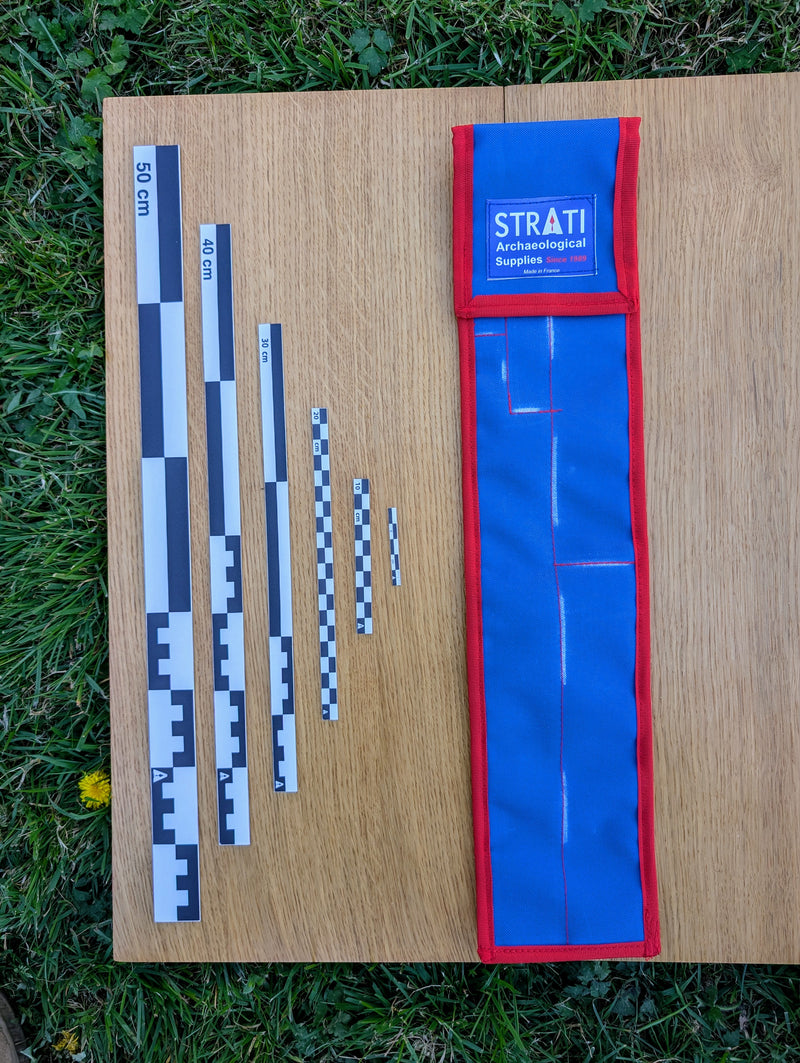 Load image into Gallery viewer, Black and white CASE 50 cm archaeological photo scale set with blue and red carrying case on wood and grass