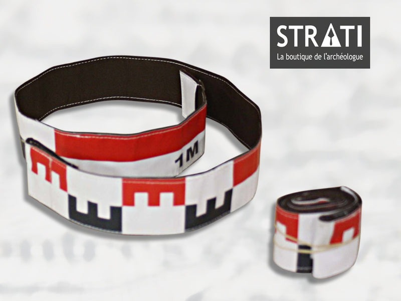 Load image into Gallery viewer, Flexible 1m CANVAS photo scale tape shown unrolled in a loop and rolled up compactly. White fabric with red and black metric markings. Reverse side is black stitched fabric.