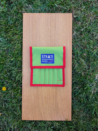 Load image into Gallery viewer, Closed green Strati tool case for precision tweezers on a wooden board and grass background