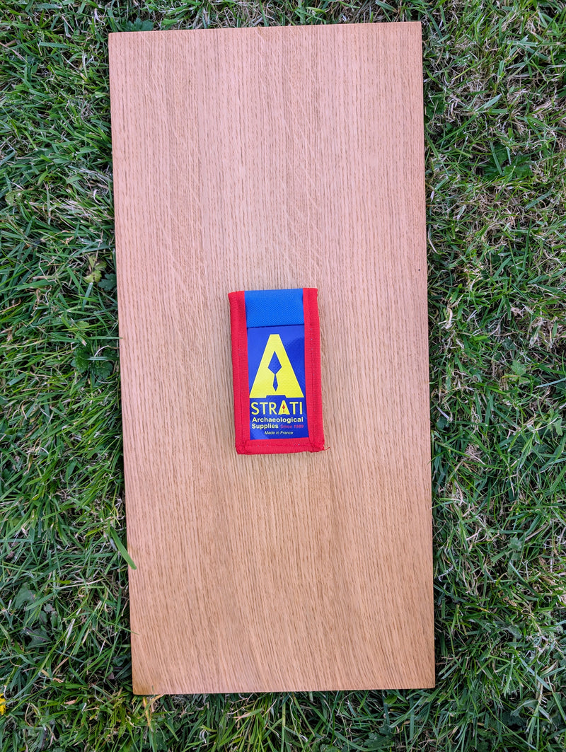 Load image into Gallery viewer, Closed Strati Minimix+ blue and red archaeological pouch with yellow logo on wood over grass