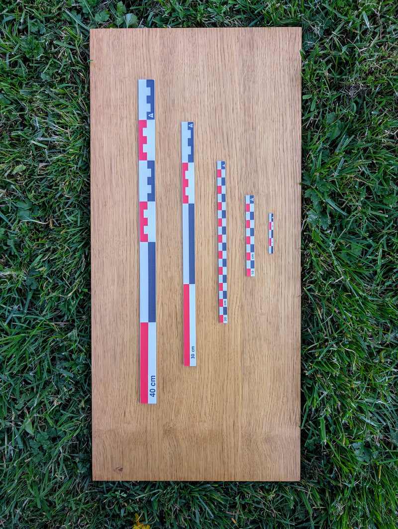 Load image into Gallery viewer, Five flat photo scales (5cm to 40cm) in RWB color on wooden board outdoors. Graduated metric set for archaeological photography.