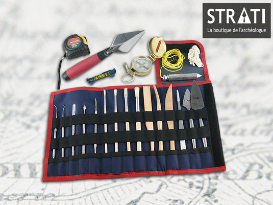 Premium wood and stainless steel archaeology tool kit in navy and red roll-up organizer with compass, tape measure and trowel on map background