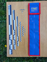 CAMA 50 cm black and white archaeological photo scale set with STRATI blue and red case on wood and grass