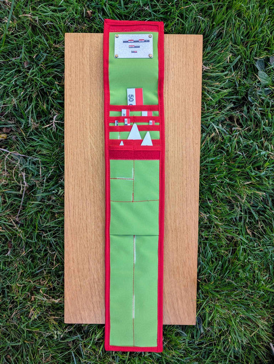 Open CANOMA 50 cm archaeological photo-scale kit in green and red STRATI case on wooden board over grass