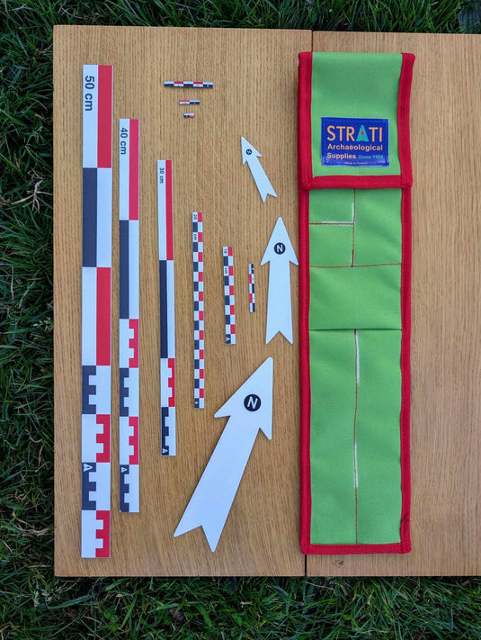 CANOMA red-white-black archaeological photo scale kit with flat scales, north arrows, magnetic scales and green case on wood