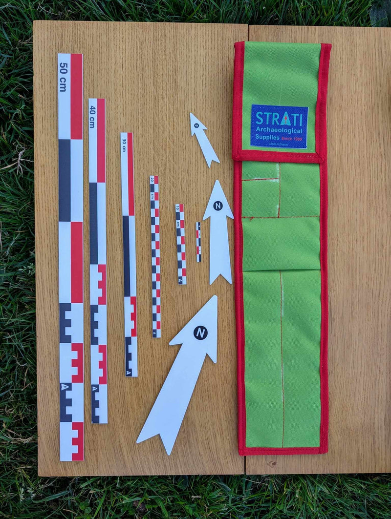Chargez l'image dans la visionneuse de la galerie, CANO 50 cm red-white-black archaeological photo scale kit with north arrows and green carrying case on wood
