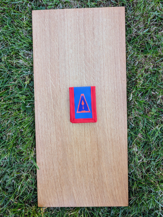 Closed Strati MicroMagnet black-white magnetic scale pouch with red and blue fabric on wood over grass