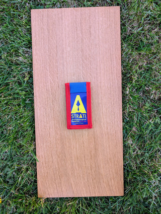 Chargez l'image dans la visionneuse de la galerie, Closed Strati Minimix+ blue and red archaeological pouch with yellow logo on wood over grass
