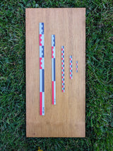 Five flat photo scales (5cm to 40cm) in RWB color on wooden board outdoors. Graduated metric set for archaeological photography.