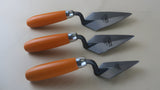 Three Strati Pi2 forged archaeological trowels with orange handles and pointed steel blades on white background