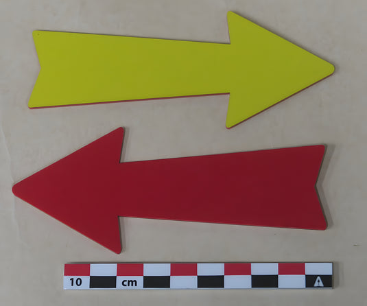 Two flat 13 cm bi-color ID arrows, yellow right-pointing and red left-pointing, on beige background with 10 cm scale