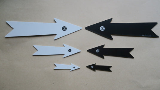 Set of three white and black north arrows for archaeology photos on beige background