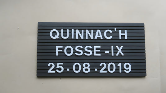 Black medium letter board 11 x 21 cm with white letters on beige wall background